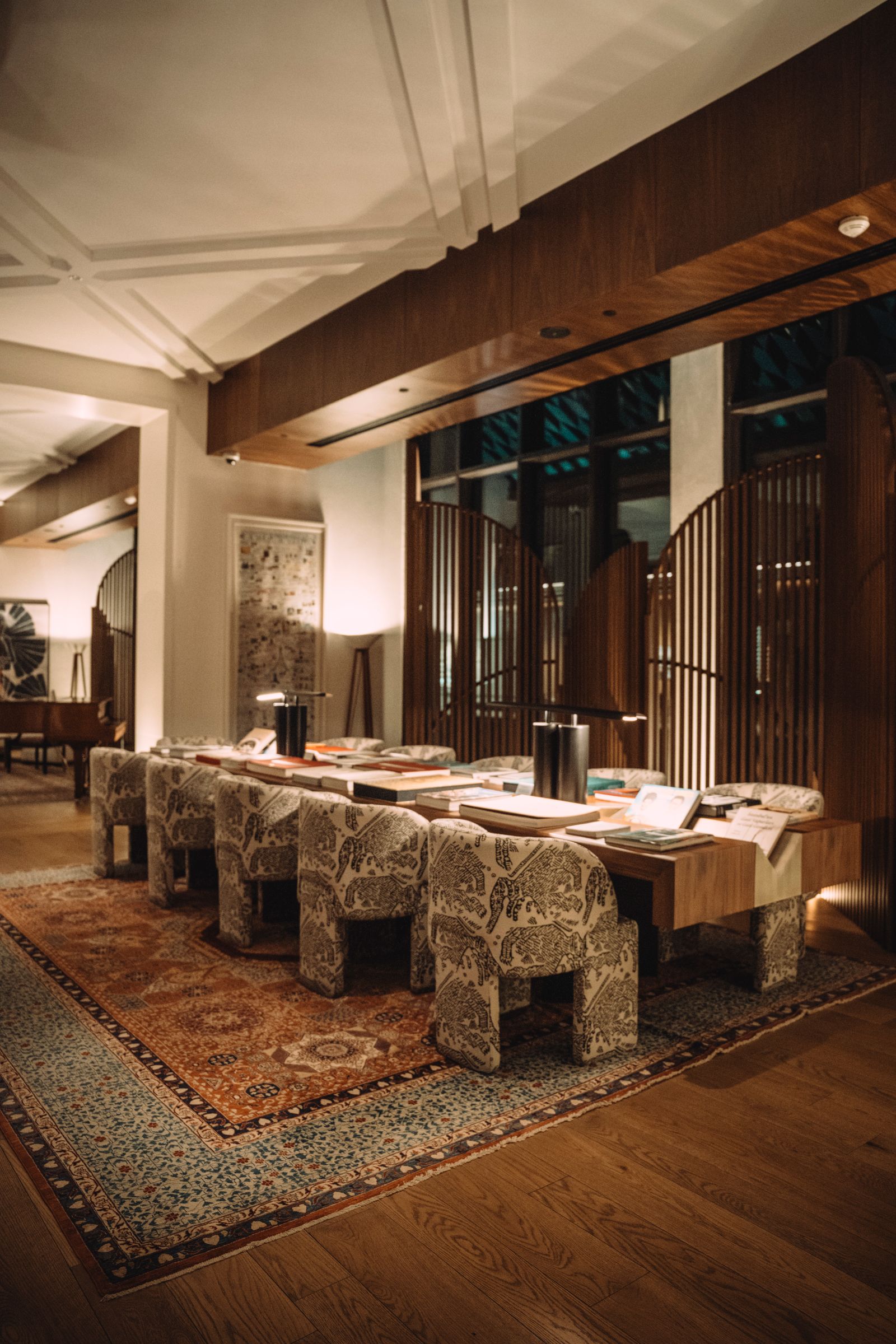 Warmly lit lounge with a reading table and layered rugs